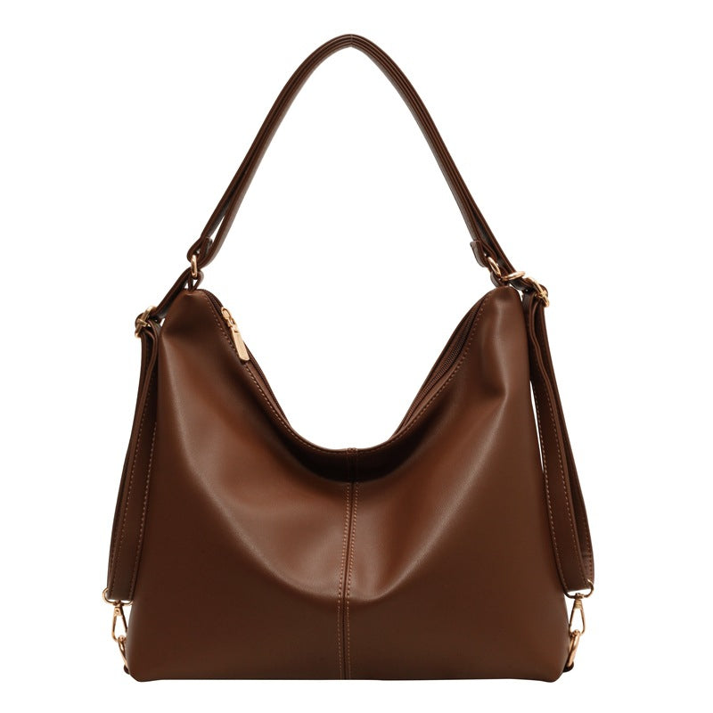 Vintage brown PU leather hobo shoulder bag with smooth texture, gold hardware, and a center-stitched vertical seam.