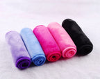 Five rolled, soft microfiber makeup remover towels in purple, blue, hot pink, light pink, and black.