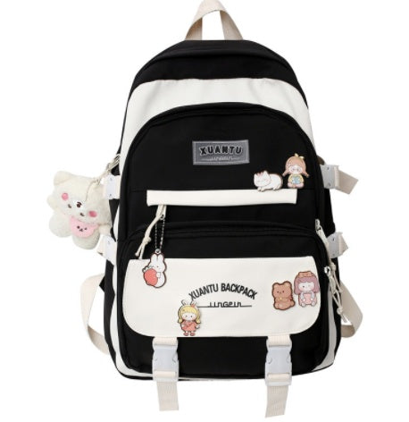 Black and white Korean-style backpack featuring cute character patches, hanging plush charm, and dual buckle straps.
