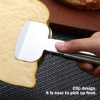 A hand holds a silver stainless steel pizza cutter with a clip design, lifting a slice of yellow food.