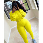A woman wears a bright yellow, ribbed two-piece leisure set featuring a long-sleeve crop top and matching leggings.