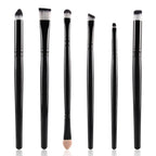 Six-piece makeup brush set with black handles and white-tipped synthetic bristles against a white background.