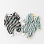 Two long-sleeved baby jumpsuits with stripes and cute embroidered dinosaurs on the chest against a white background.