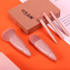 Five-piece rose-gold makeup brush set with soft pink bristles and a matching rectangular plastic storage case.