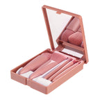 A 5-piece pink makeup brush set in a matching compact case with an integrated mirror.