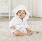 Baby in a white, soft cotton hooded bathrobe with cute lamb ears, sitting on a rug.