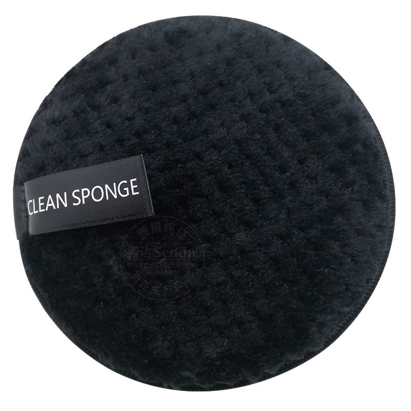 A circular, black textured makeup sponge by Digitaldistribution375 featuring a "CLEAN SPONGE" label on a white background.