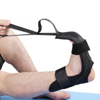 Black fabric foot stretching brace with Velcro straps, held by hands to pull the foot into a flexed position.