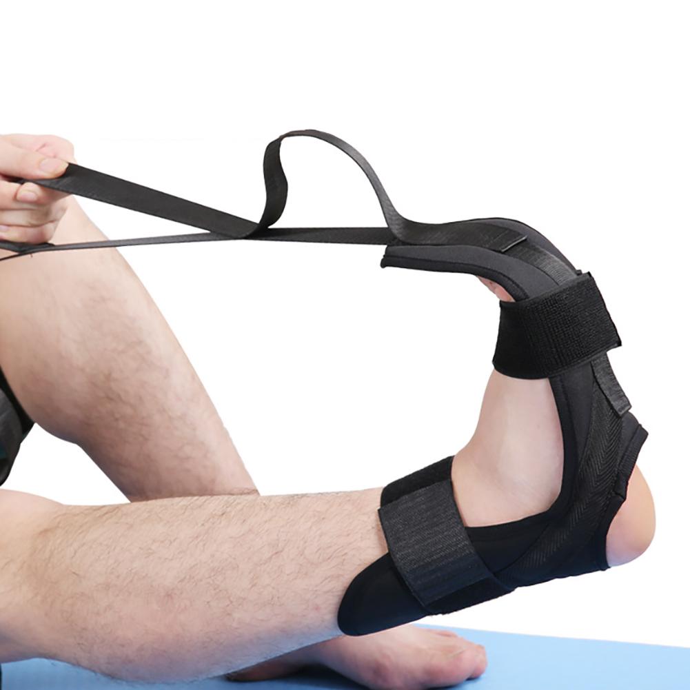 Black fabric foot stretching brace with Velcro straps, held by hands to pull the foot into a flexed position.