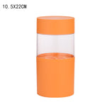 Orange cylindrical makeup brush holder with a clear middle section and internal organizer base for brushes and pencils.