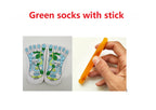 White reflexology socks with colorful acupressure charts and an amber-colored massage stick held in a hand.