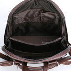 Interior of a brown soft leather backpack featuring zippered compartments and fabric organizer pockets.