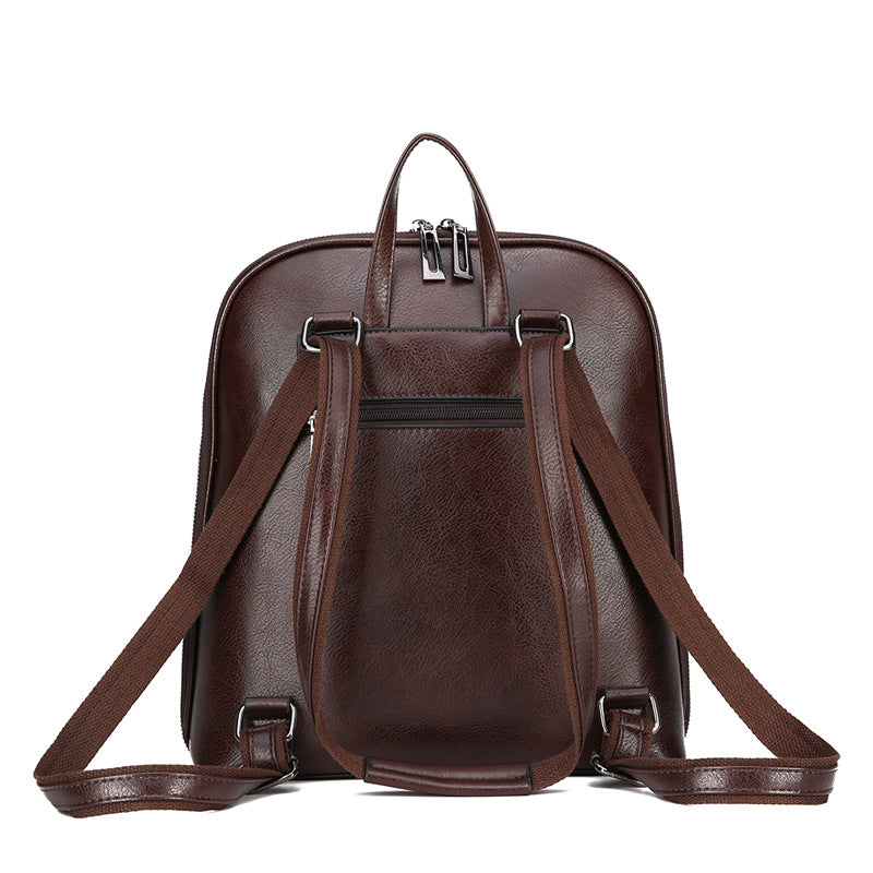 Brown faux leather backpack with adjustable straps, top handle, zippered compartments, and silver hardware.