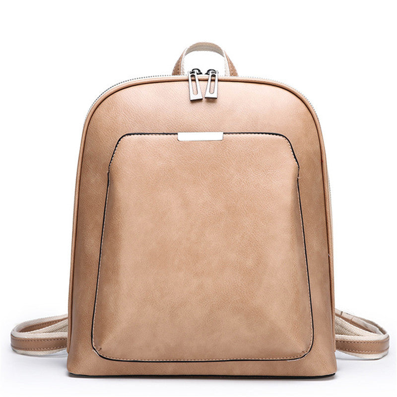 Minimalist tan soft leather backpack with a structured silhouette, silver hardware, and adjustable canvas straps.