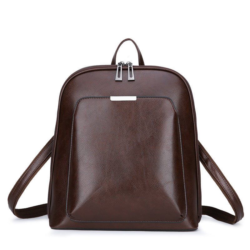 Dark brown, structured leather-look women’s backpack with silver hardware, dual zip closure, and adjustable straps.