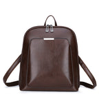 Dark brown, structured leather-look women’s backpack with silver hardware, dual zip closure, and adjustable straps.