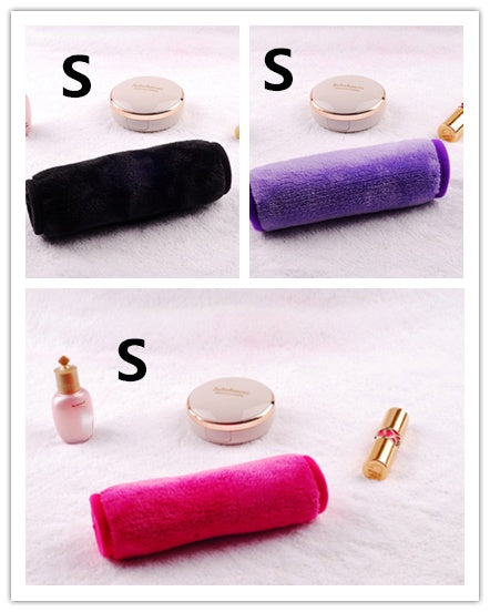 Three soft, plush makeup remover towels in black, purple, and pink, displayed on a textured white surface.