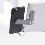 Gray aluminum alloy bracket attaches a smartphone to the side of a silver laptop for dual-screen viewing.