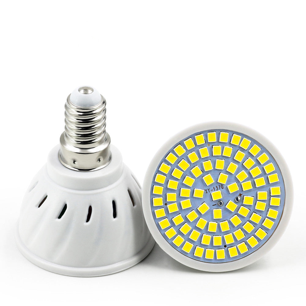 White plastic LED lamp cup with a screw base, showing a flat panel of yellow LED diodes on a light blue background.