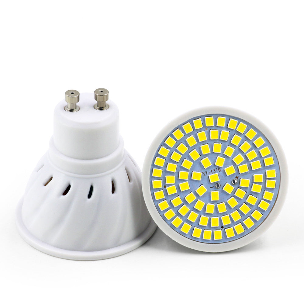 White plastic LED lamp cup with many small yellow square light chips arranged in circular patterns on a white base.