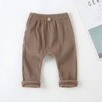Brown ribbed baby leggings with an elastic waistband, decorative center button, and cuffed hems on a white background.