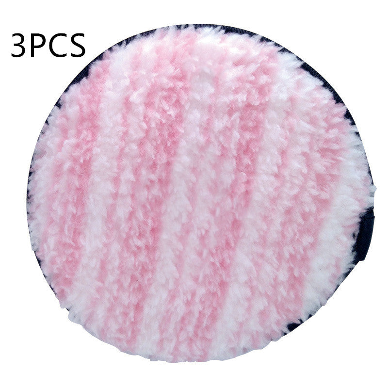 A circular, fuzzy, pink and white striped makeup puff set of 3 with a dark blue backing.