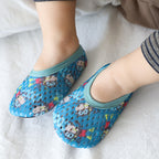 Blue mesh baby shoes with monkey print and teal trim worn on baby feet.