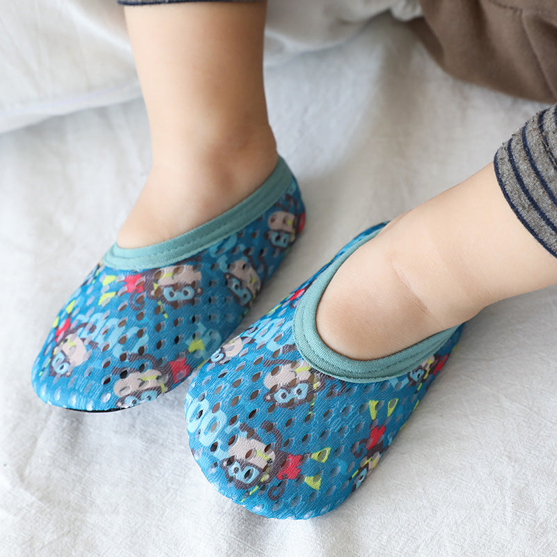 Blue mesh baby shoes with monkey print and teal trim worn on baby feet.