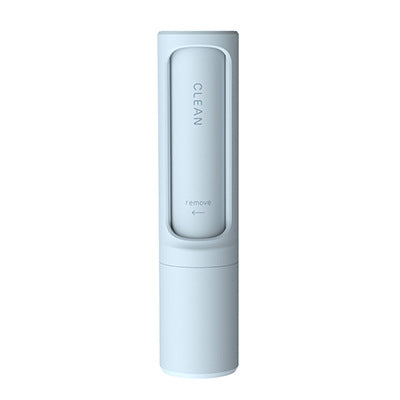 Light blue portable pet hair remover brush with self-cleaning mechanism and directional indicator text.
