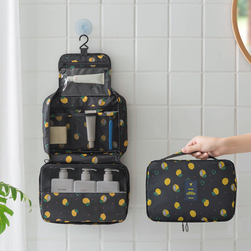 Black travel toiletry bag with yellow lemon print, hanging hook, clear pockets, and organized mesh compartments.