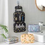 Digitaldistribution375 travel cosmetic bags in black, blue, and yellow with lemon and flamingo prints in a bathroom.