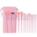 A 13-piece pink makeup brush set with soft fiber bristles and a matching pink velvet drawstring storage pouch.