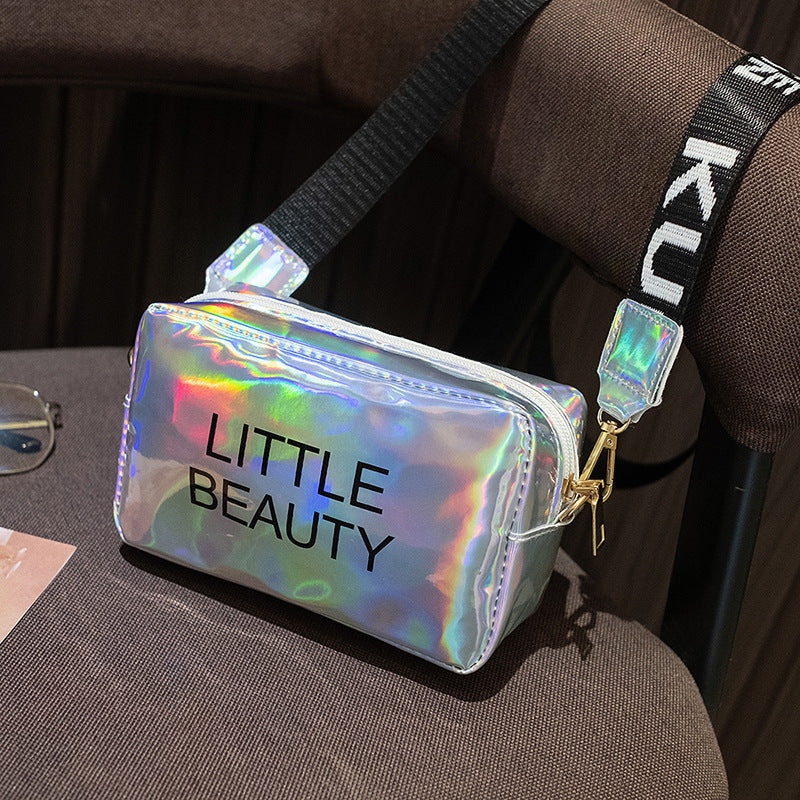 Holographic, waterproof cosmetic bag with "LITTLE BEAUTY" text, zipper closure, and black adjustable shoulder strap.