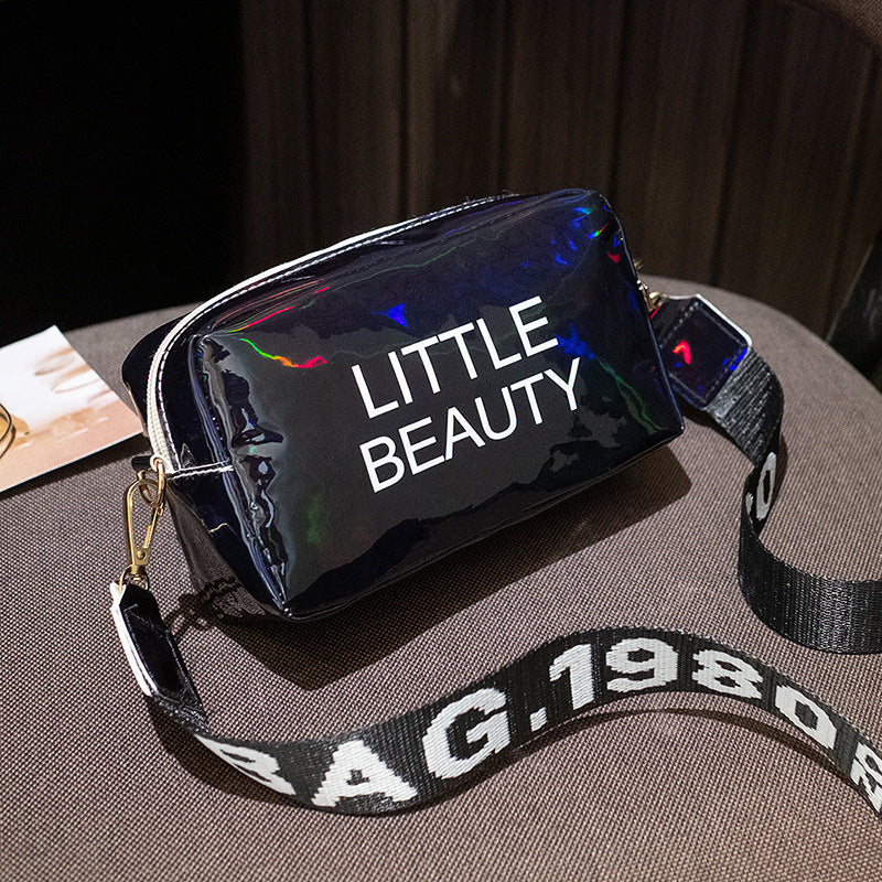 Black holographic cosmetic bag with "LITTLE BEAUTY" print and a branded "BAG 1980" adjustable shoulder strap.