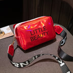 Shiny red waterproof cosmetic bag with "LITTLE BEAUTY" text, a white zipper, and a black-and-white branded shoulder strap.