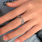 Antique silver-toned adjustable ring featuring detailed angel wing ends worn on a finger.