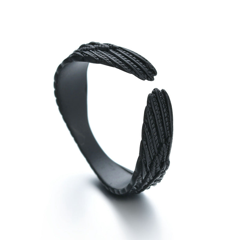Matte black adjustable ring featuring intricate, textured angel wing detailing in a wrap-around hip hop style.