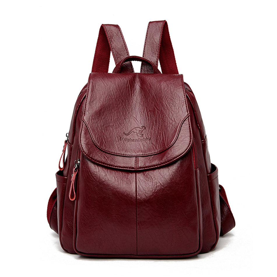 Burgundy soft leather women's backpack with flap closure, Kangaroo logo, and adjustable straps on a white background.