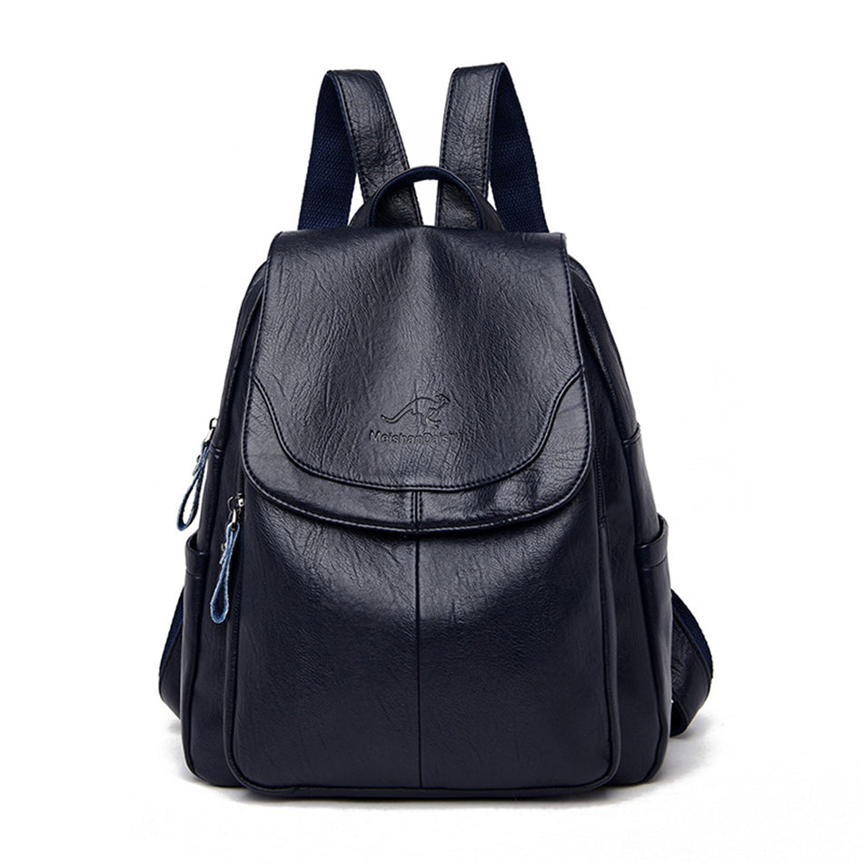 Navy blue soft leather women's backpack with a front flap, top handle, and adjustable shoulder straps.