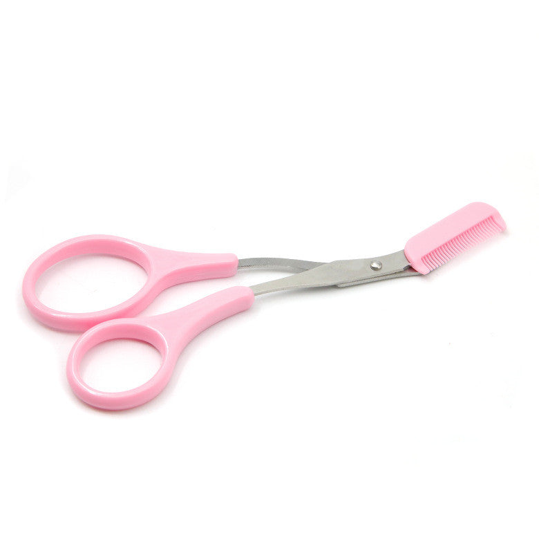 Pink plastic eyebrow trimmer scissors featuring metal blades and an attached hair-grooming comb on a white background.
