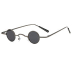 Retro-style unisex sunglasses featuring ultra-small, circular dark grey lenses and a slim, metallic gunmetal wire frame.