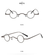 Small retro round glasses with thin gunmetal grey metal frames and clear lenses, shown from front and side angles.
