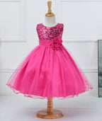 Hot pink flower girl dress with sequin bodice, satin waistband, large fabric flower, and layered tulle skirt on mannequin.