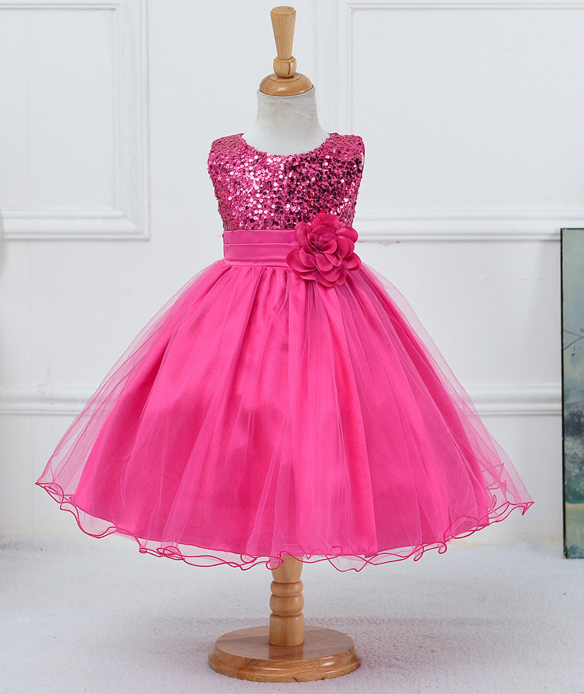 Hot pink flower girl dress with sequin bodice, satin waistband, large fabric flower, and layered tulle skirt on mannequin.