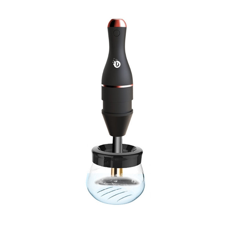 Matte black electric makeup brush cleaner with rose gold accents and a clear glass cleaning bowl.