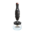 Matte black electric makeup brush cleaner with rose gold accents and a clear glass cleaning bowl.