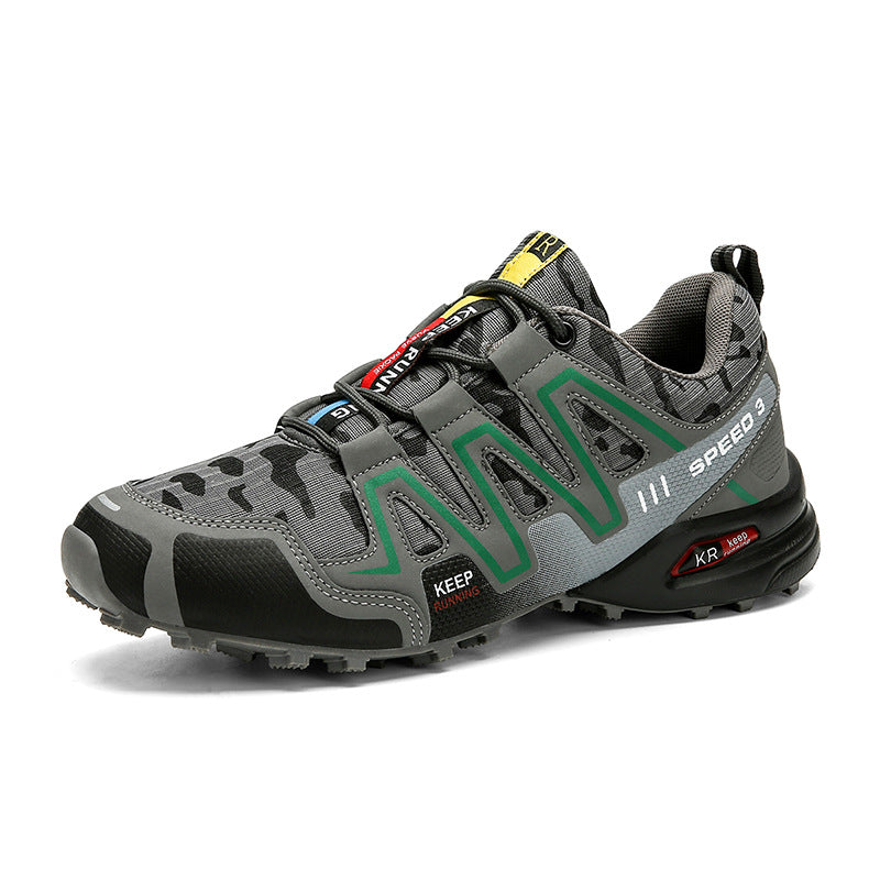 Grey camouflage hiking sneaker with green accents, black reinforced toe, lace-up closure, and rugged non-slip sole.