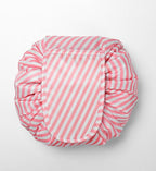 Round, pink-and-white striped cosmetic bag with a cinched, drawstring-style closure on a white background.