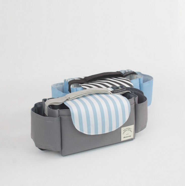 Two grey fabric stroller organizers with cup holders and striped flap lids in blue and black against a white background.