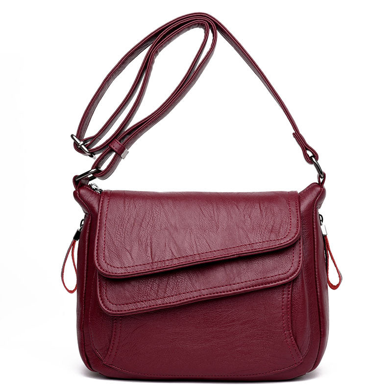 Burgundy soft leather crossbody bag with an adjustable strap, front flap pocket, and silver-tone hardware.